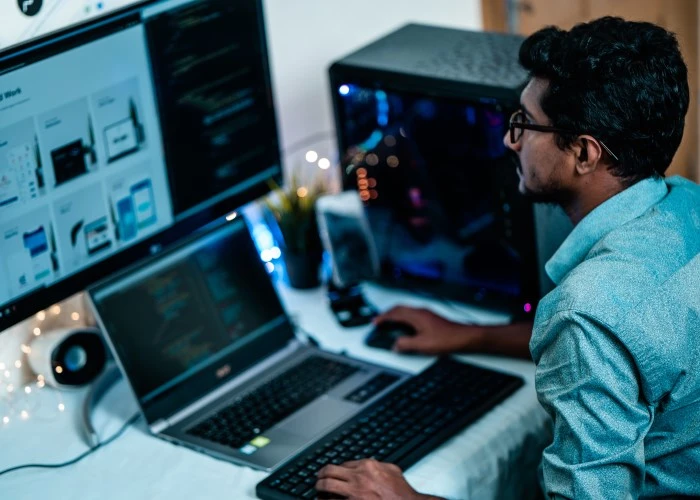 An Asian man working on something on his computer