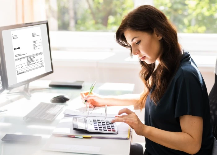 Lady using a calculator at desk